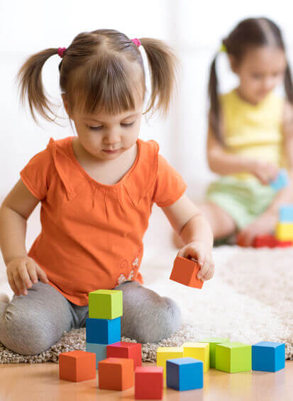 Kindergruppen Ein Mädchen spielt mit Bauklötzchen